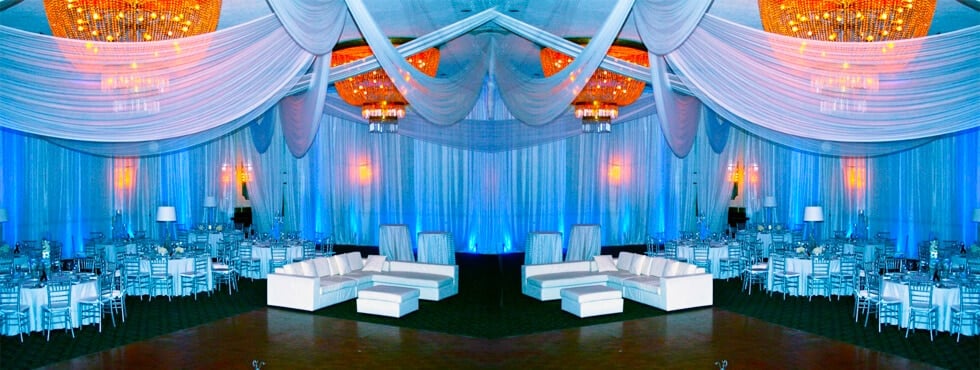 A great example of how well a pipe and drape rental can go with lounge chair rentals in an indoor setting for a party or wedding.