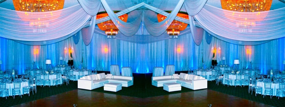 A great example of how well a pipe and drape rental can go with lounge chair rentals in an indoor setting for a party or wedding.